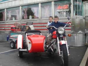 Two boys on a moped in front of a diner