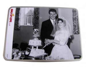 wedding photo of a couple cutting a cake in black and white on a tin box