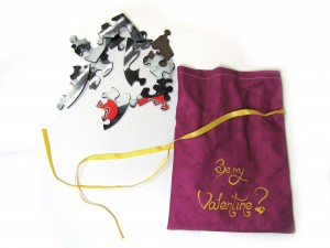 Bag of Love Pieces of a jigsaw next to a purple pouch with text on it