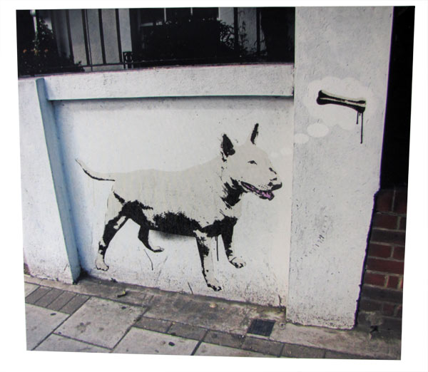 Dog painted on a white wall in the street