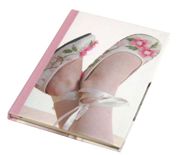 A little girls feet on the cover of a diary