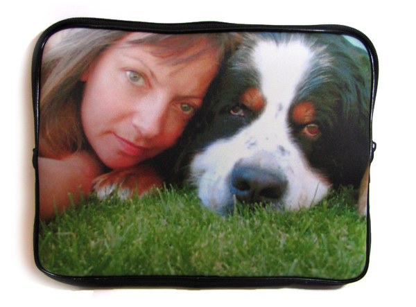 Woman and dog lying on the grass on the cover of a laptop bag
