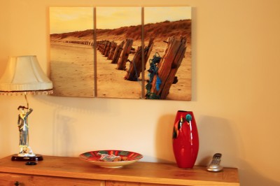 A triptych canvas print of a sandy beach above a shelf
