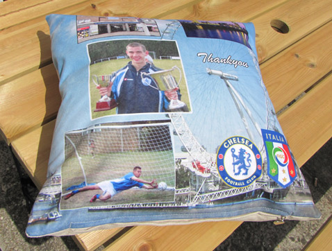 Football photos printed on cushion lying on a wooden table