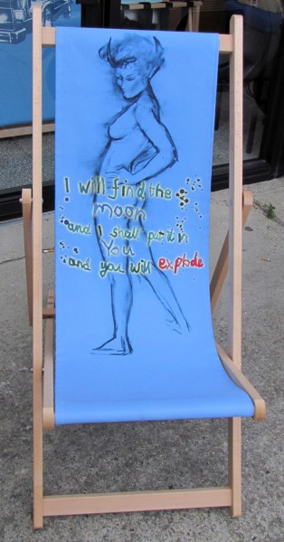 Wooden deckchair with blue seat printed with sketch of woman and poem