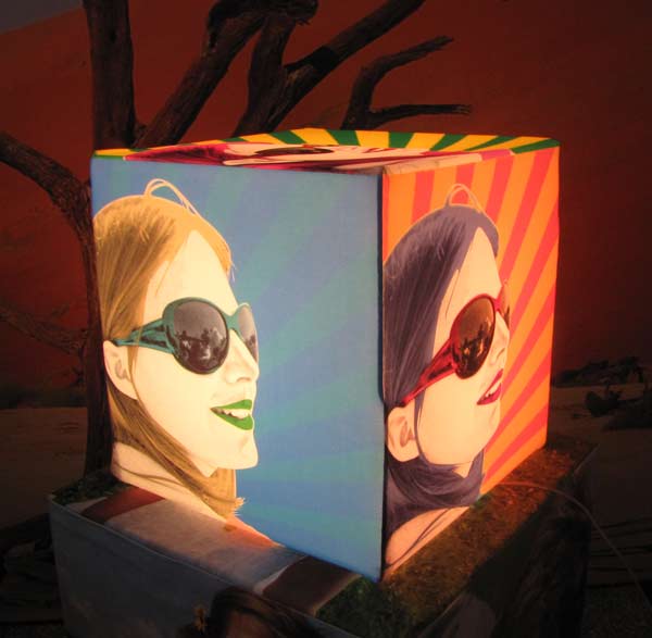 Woman with sunglasses on a light cube