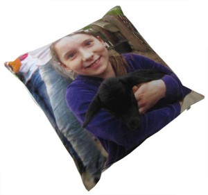 Girl holding a black goat on a cushion