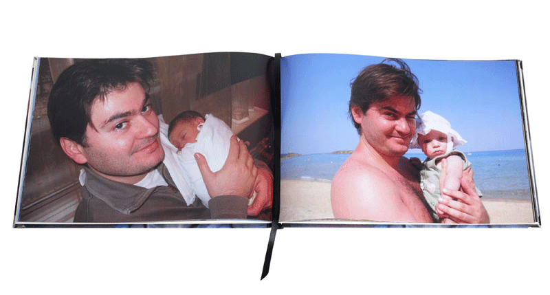 A father holding a baby on two pages of an open photo book