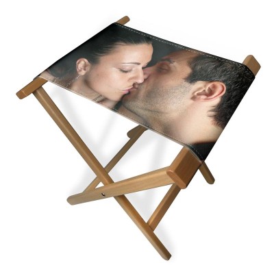 Man and woman kissing on the seat of a folding stool