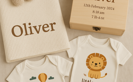 A selection of personalised baby gifts including a blanket, baby grows, and memory box