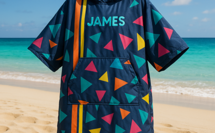 A custom-designed waterproof changing robe on a beach with a sunny ocean view.